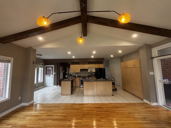 Open-concept kitchen and living area with vaulted ceiling and exposed beams