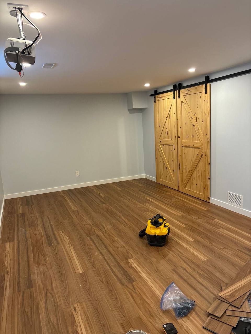 Finished basement with vinyl plank flooring and custom barn doors